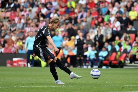 Martin Odegaard of Arsenal kicking a soccer ball.