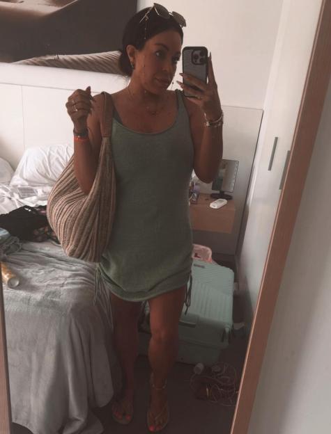 Woman taking a mirror selfie in a hotel room.