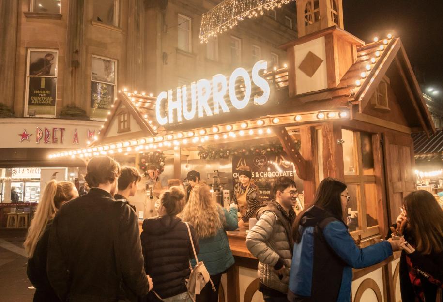 Churros food stall at the Newcastle Christmas market with people queuing up.