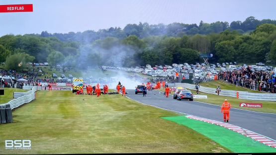 Race track accident with emergency personnel attending to the injured.