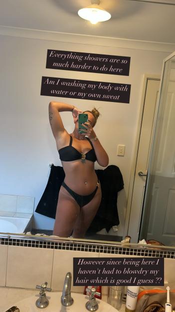 Polly Spellman in a black bikini taking a mirror selfie, with text overlay discussing challenges with showering and hair drying.