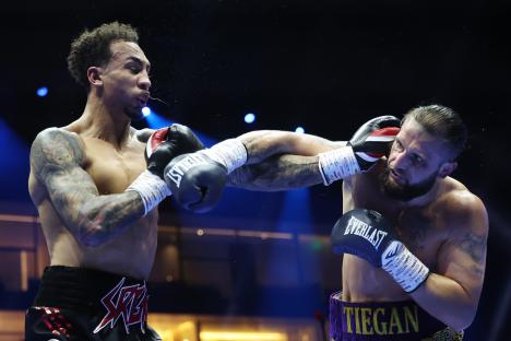Liam Cameron punches Ben Whittaker in a light heavyweight boxing match.