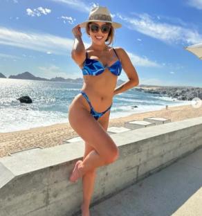 Brittney Palmer in a blue bikini at the beach.