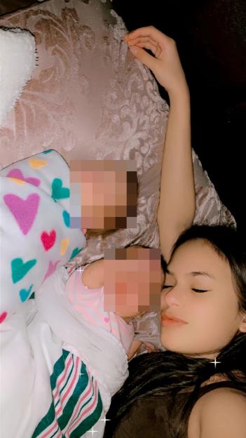 A young mother sleeping with her two babies.