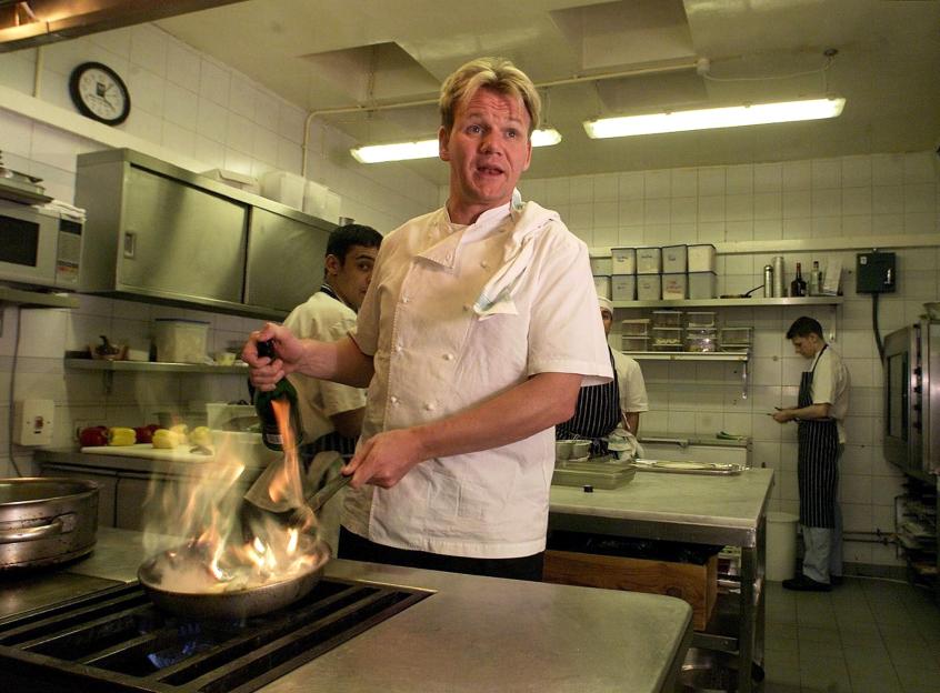 Gordon Ramsay cooking in a kitchen.