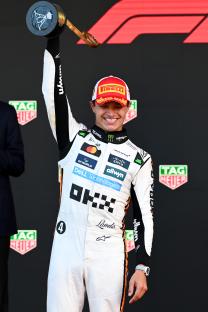 Lando Norris holding a trophy after winning a race.