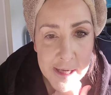 Woman demonstrating a face lift makeup technique.