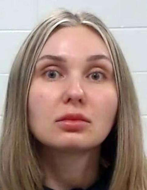 Mugshot of a woman with blonde hair, light skin, and wide-open eyes looking directly at the camera.