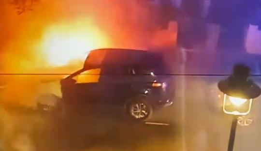 Screengrab of firefighters extinguishing a burning car.
