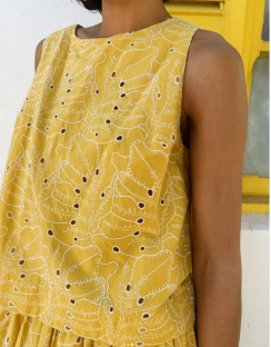 Mustard yellow sleeveless top with white leaf embroidery.