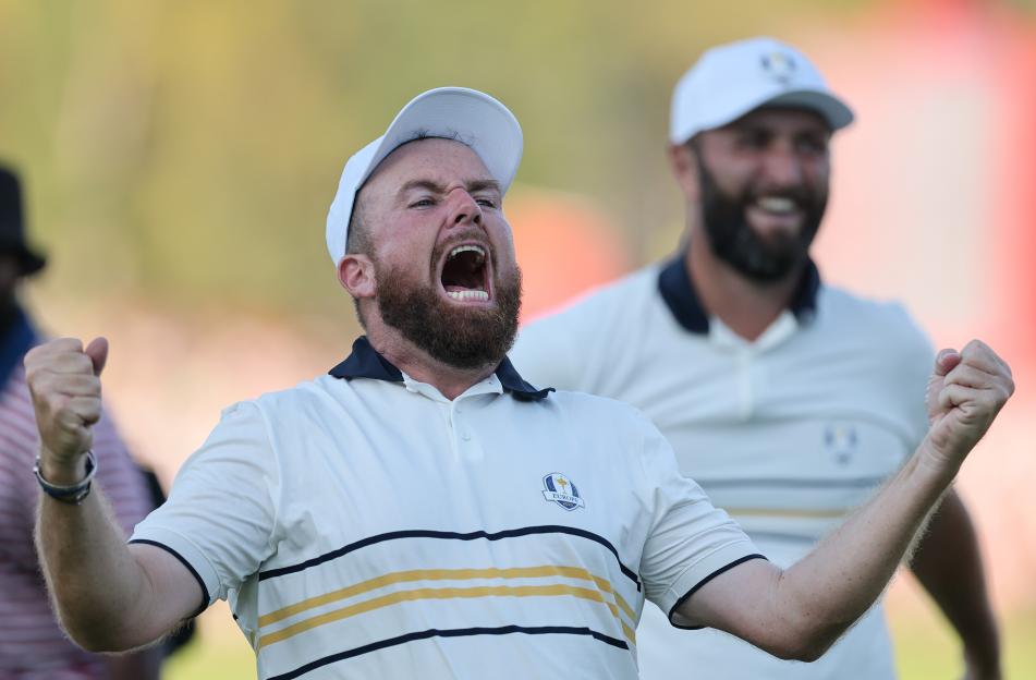 Shane Lowry and Jon Rahm celebrate a putt to retain the Ryder Cup.