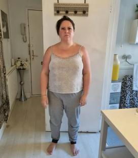 Full-length photo of a woman in a tank top and sweatpants.