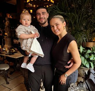 Molly Mae Hague, Tommy Fury, and their baby daughter in a restaurant.