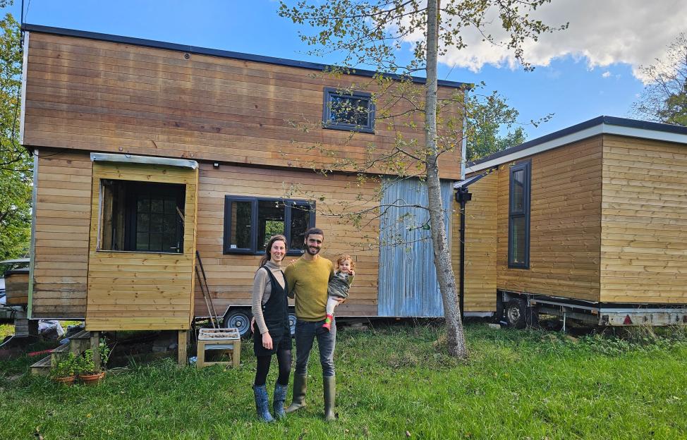 Vicky Freese-Brayer, her husband Uriah, and their daughter Naya stand in front of their tiny home.