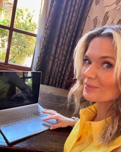 Woman in yellow shirt using laptop.
