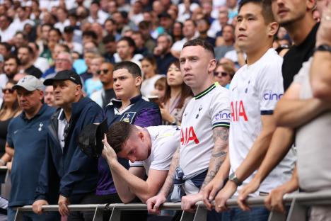 Dejected Tottenham Hotspur fans at a football match.
