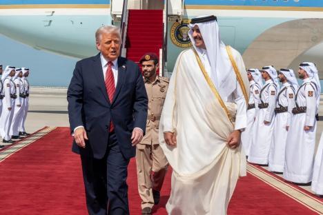 An image collage containing 1 images, Image 1 shows President Trump and the Emir of Qatar walking on a red carpet at an airport