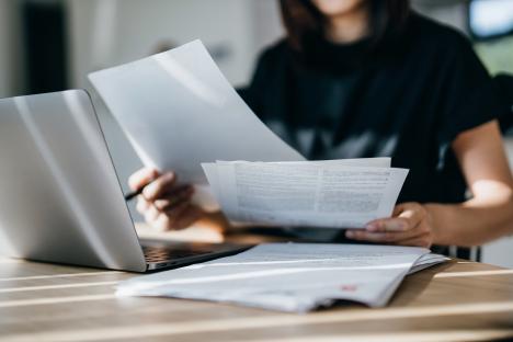 Woman reviewing financial documents at home.