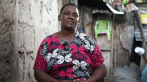 Woman in patterned shirt speaks about malaria.