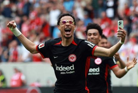 Hugo Ekitike of Eintracht Frankfurt celebrates, holding a phone.