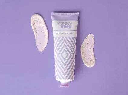 a tube of skinny tan pre tan primer on a purple surface