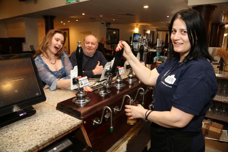 Bartender pouring a pint of beer at a pub.