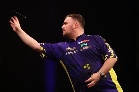 Luke Littler of England throwing a dart during a darts match.