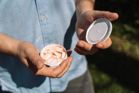 A person opens a container of snus.