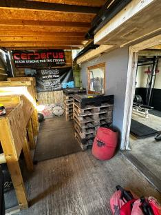 Interior of a gym with weightlifting equipment and storage.