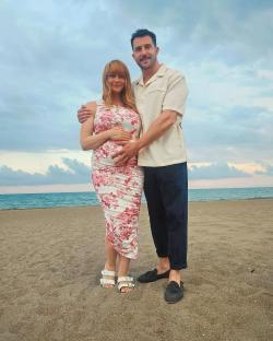 Michael Parr and his partner on a beach, she is pregnant.