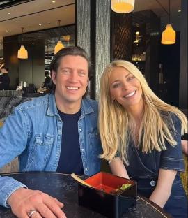 Tess Daly and a man sitting at a restaurant table.