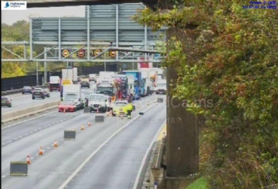 Traffic on a highway is at a standstill due to an oil spill, with cars and trucks backed up for miles.