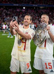 Harry Kane and Eric Dier of Bayern Munich celebrating with the Meisterschale trophy.