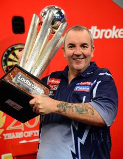 Phil Taylor holding the Ladbrokes World Darts Championship trophy.