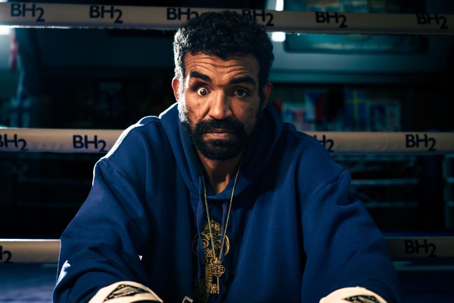 Portrait of a man wearing a blue hoodie and gold necklace.