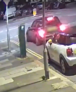 Two Mini Coopers parked on a city street at night.
