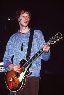 Andy Bell, Oasis's new guitarist, playing a guitar.