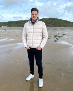 Dr. Alex George on a beach.