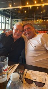 Two men sitting together at a restaurant table.