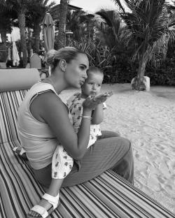 Black and white photo of a woman and a toddler blowing kisses.