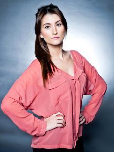a woman in a pink shirt has her hands on her hips