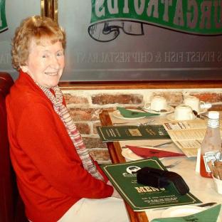Woman in red sweater at a restaurant.