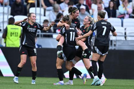 Arsenal women's soccer players celebrating a goal.