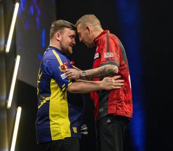 Nathan Aspinall congratulates Luke Littler after a darts match.