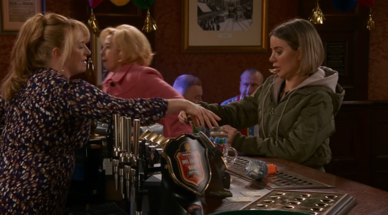 Screenshot of two women at a pub bar.