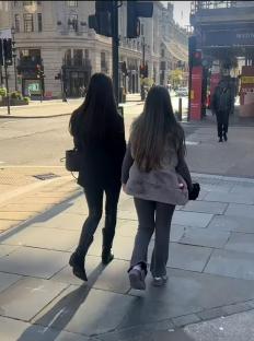 Two women walking down a city street.