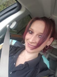 Woman with purple hair in a car.