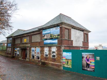 Entrance to former Grange lido with posters on the brick building.