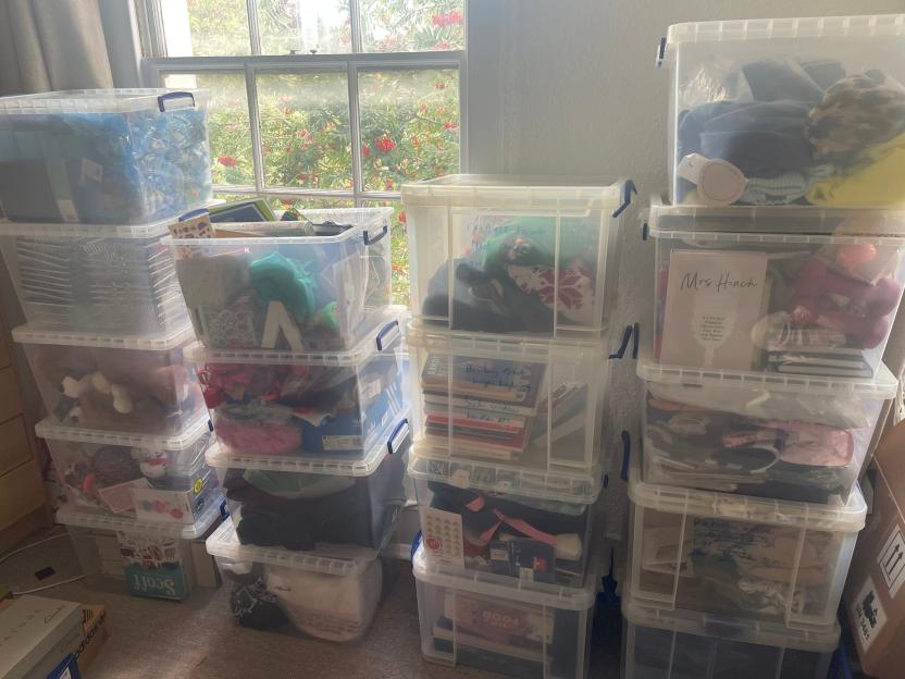 Stacks of clear plastic storage bins filled with household items.