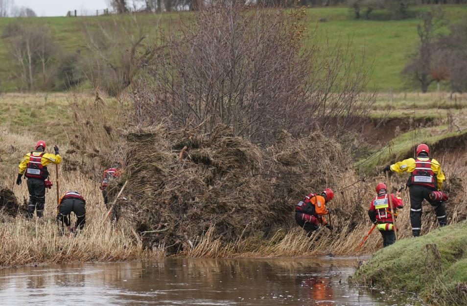 Search and rescue team searching a riverbank.